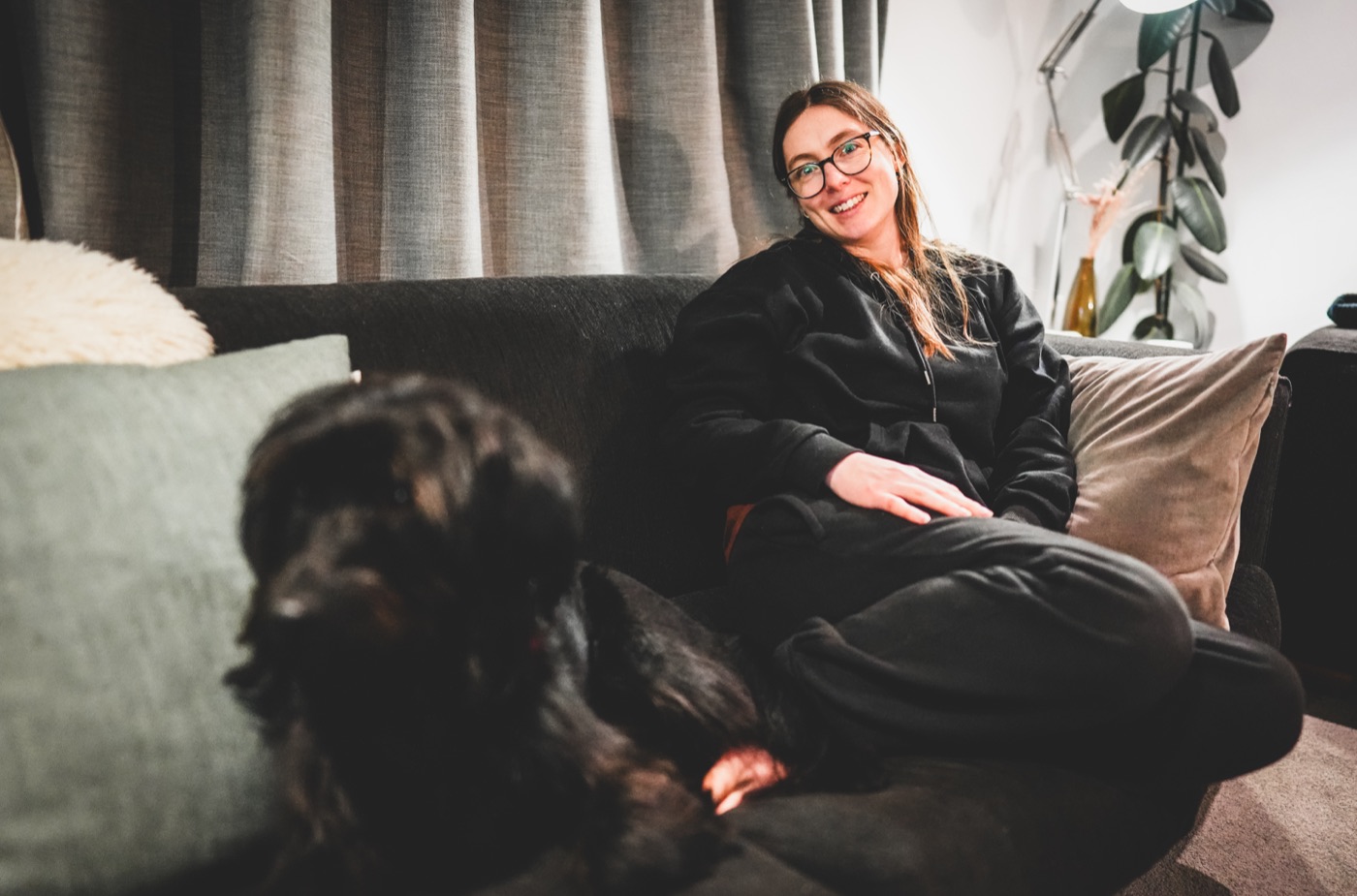 Woman with her dog on a couch, low light