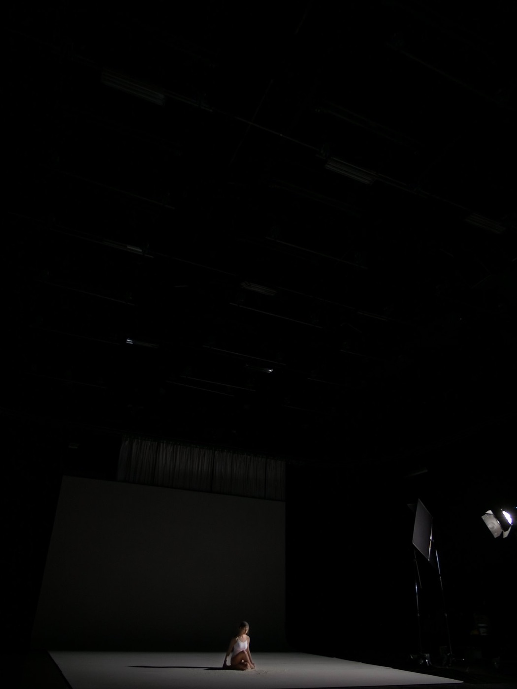 Dancer in white against a black backdrop