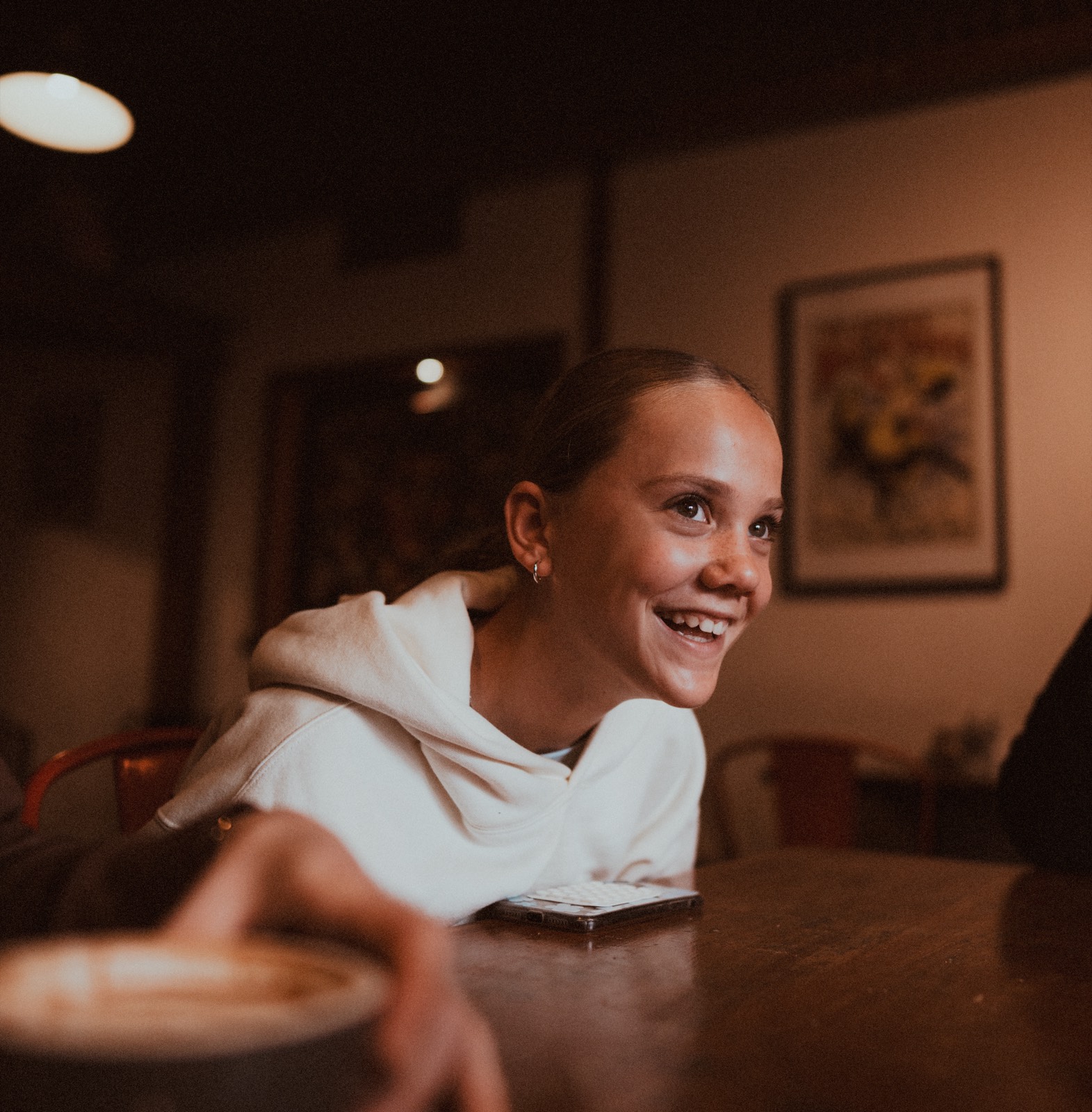 Girl laughing across a café table