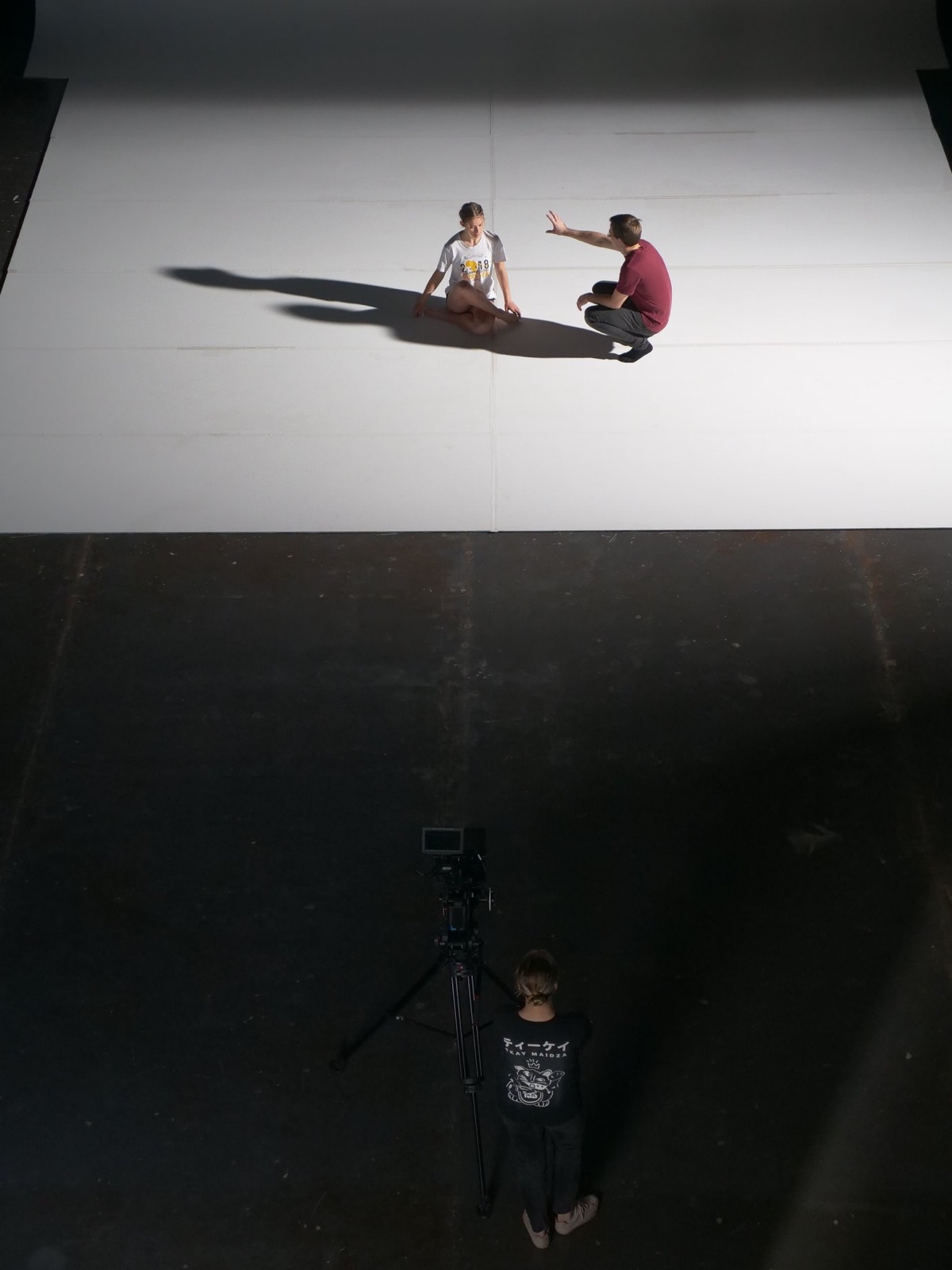 Overhead view of a director and dancer on set