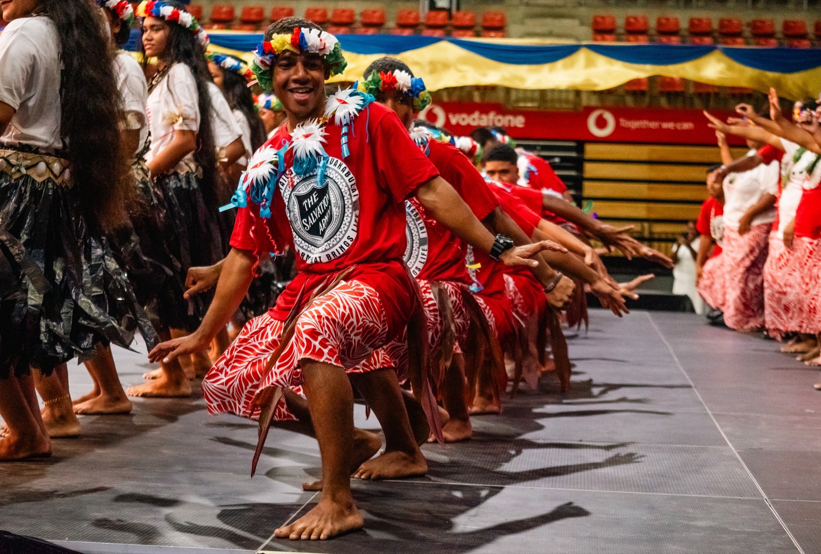 Pasifika dancers in red mid-performance