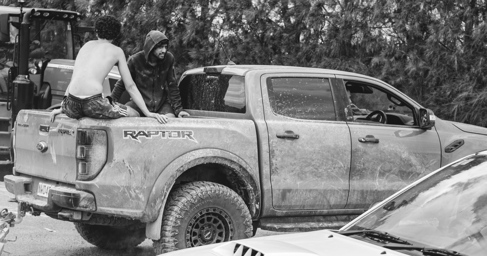 Mud-covered ute with two figures, black and white