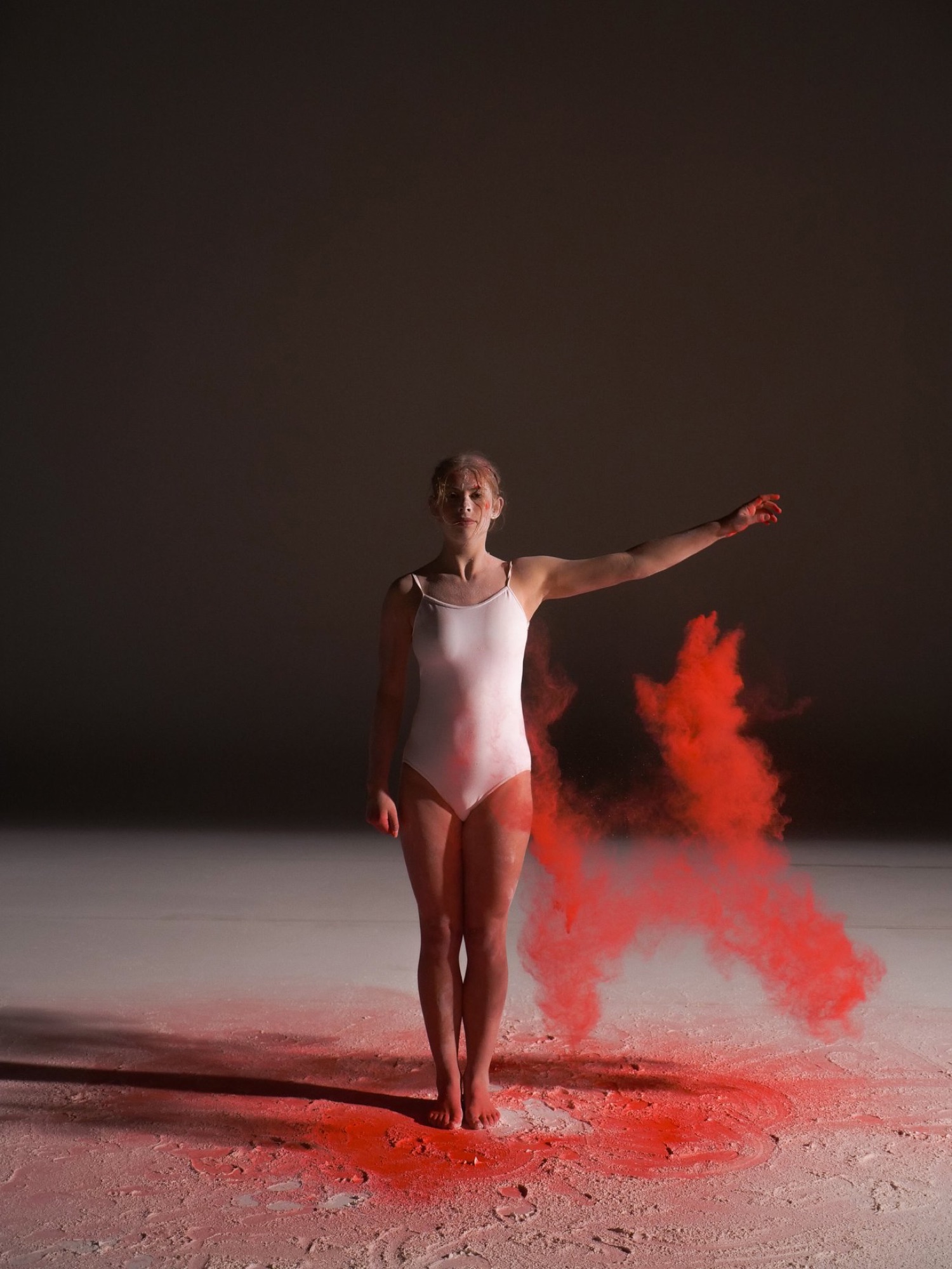 Dancer mid-turn in a burst of red pigment